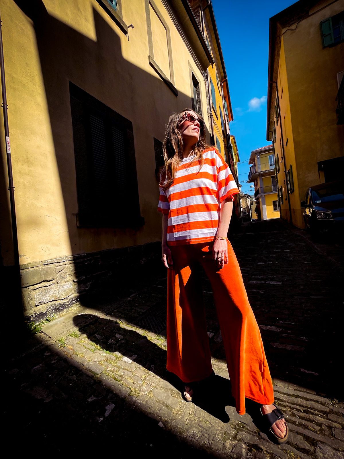 Haut rayé et pantalon orange dans une ruelle