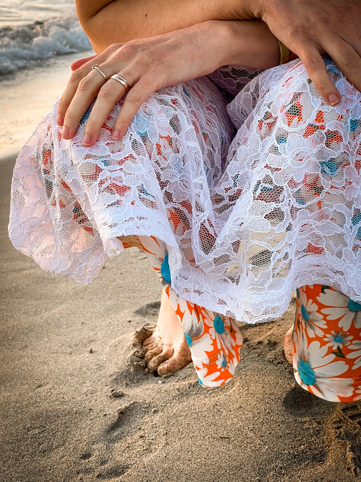 Détail d’une robe en dentelle fleurie sur le sable