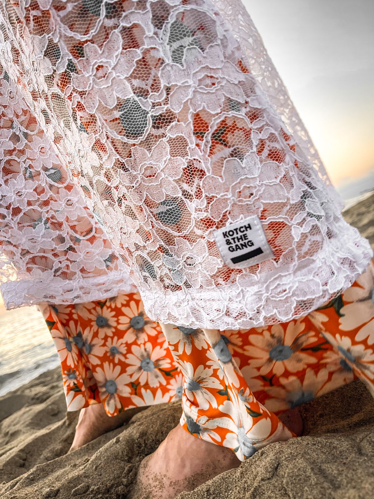 Robe en dentelle et pantalon fleuri sur la plage