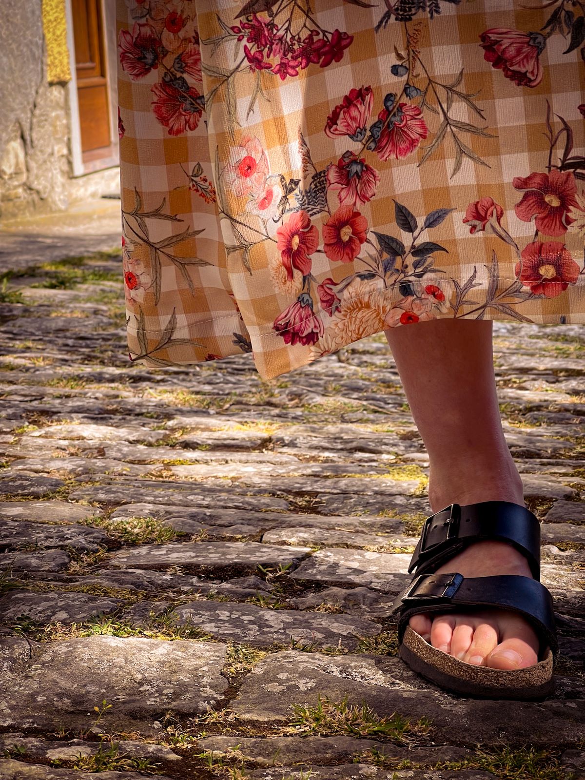 Robe fleurie et sandales sur les pavés
