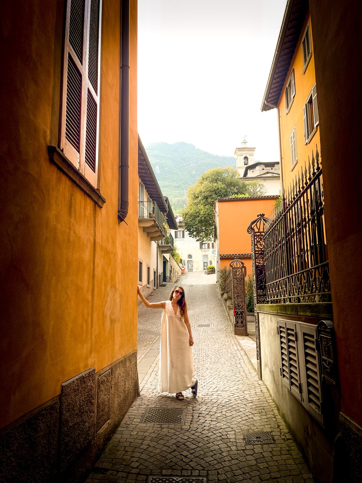 Silhouette en robe blanche au bout d’une ruelle ensoleillée