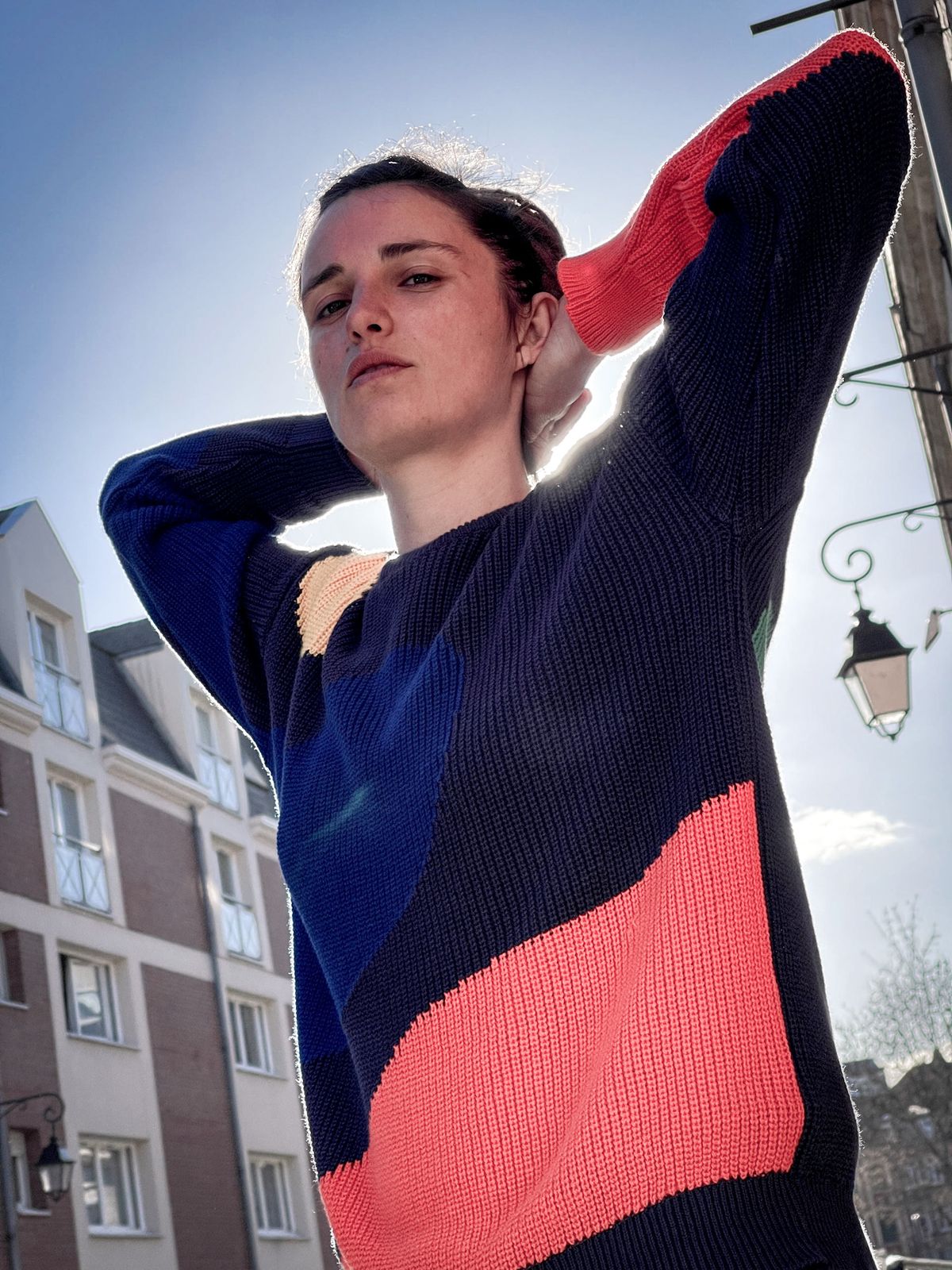 Pull rayé rouge et marine, bras levé