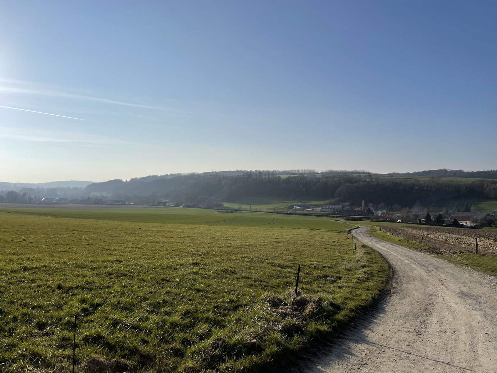 Chemin de terre entre les champs, collines au loin