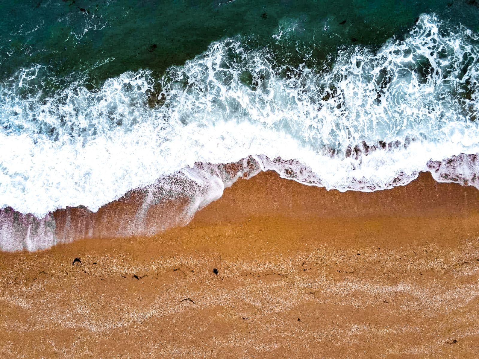 Vague sur le sable vue du ciel par drone