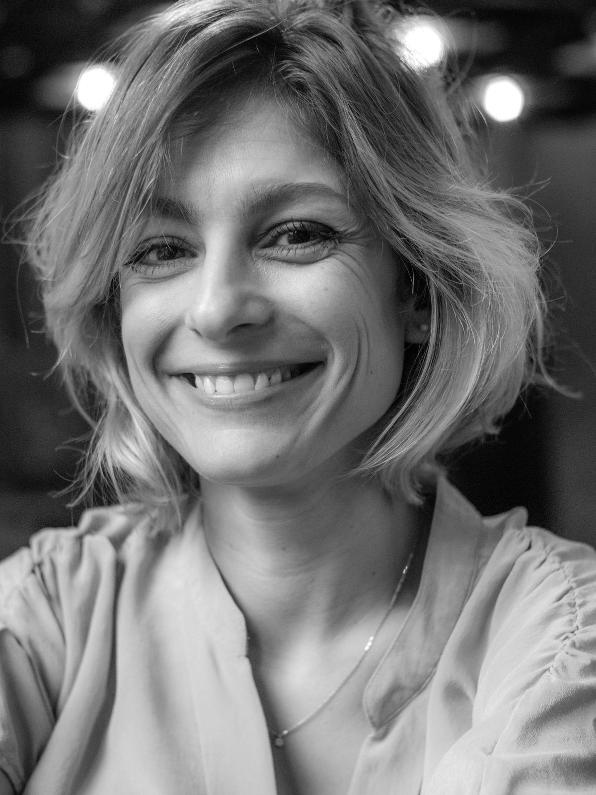 Portrait professionnel en noir et blanc, femme au sourire franc