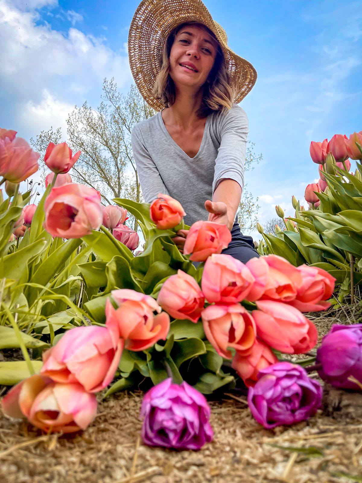 Productrice de fleurs accroupie au milieu des tulipes