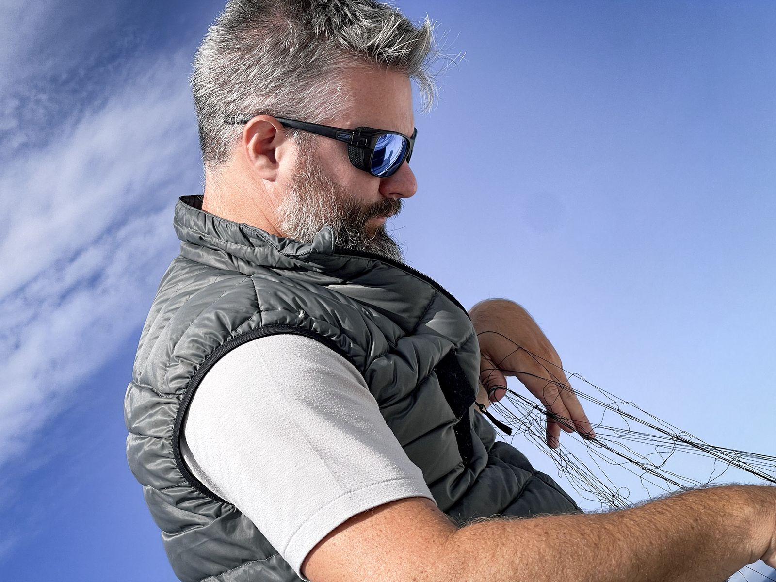 Navigateur aux lunettes de soleil réglant un cordage