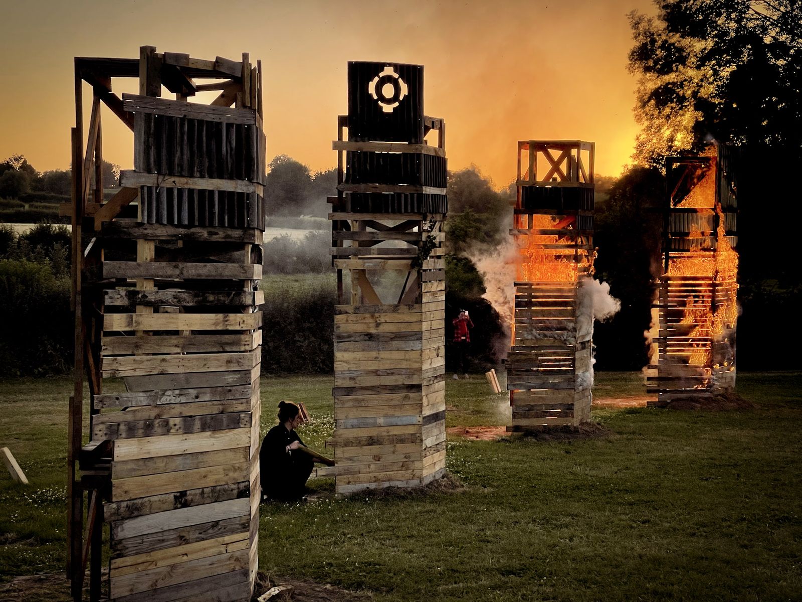 Tours de palettes en feu dans un champ au crépuscule