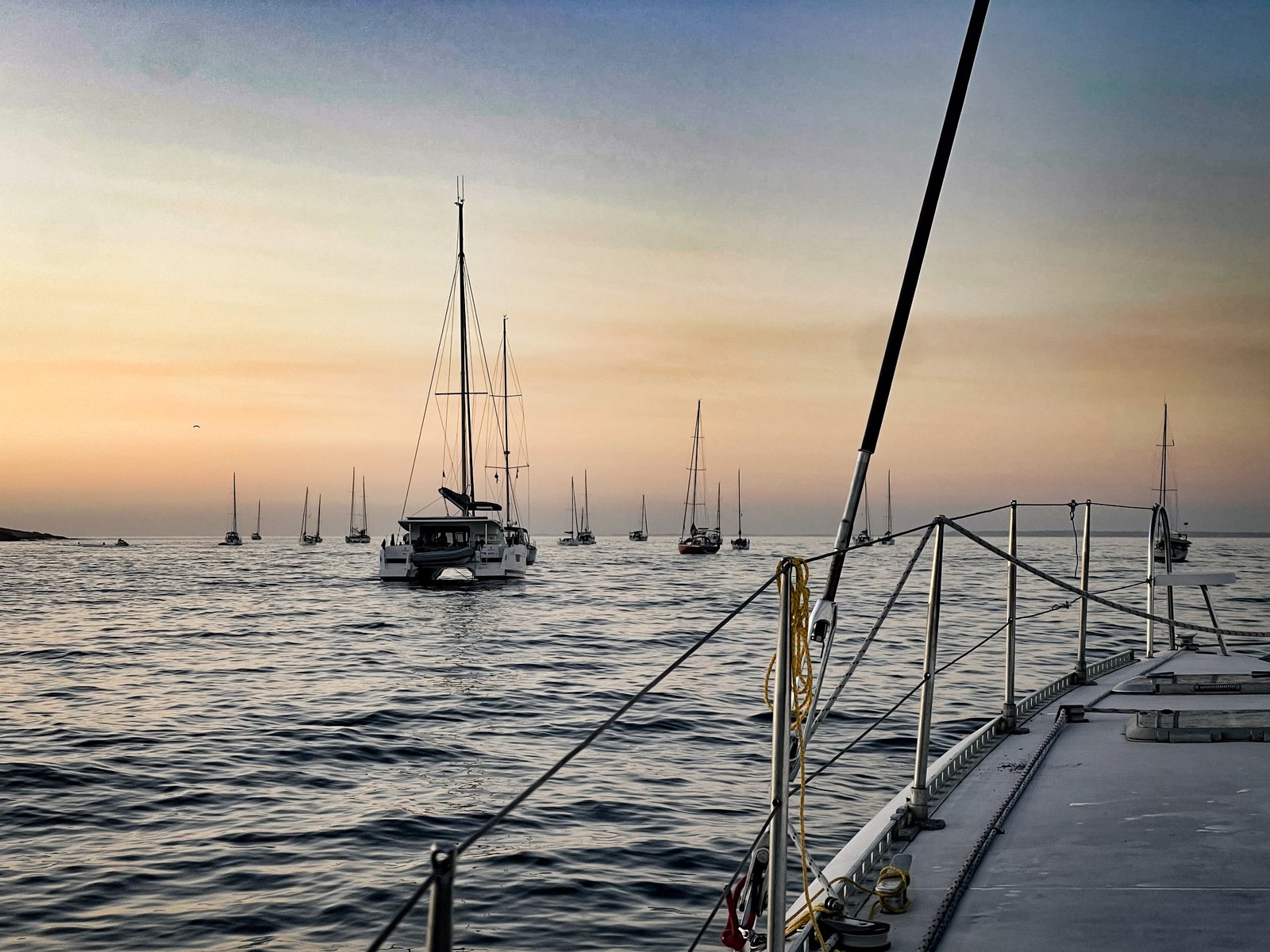 Voiliers au mouillage au coucher du soleil, vus depuis le pont