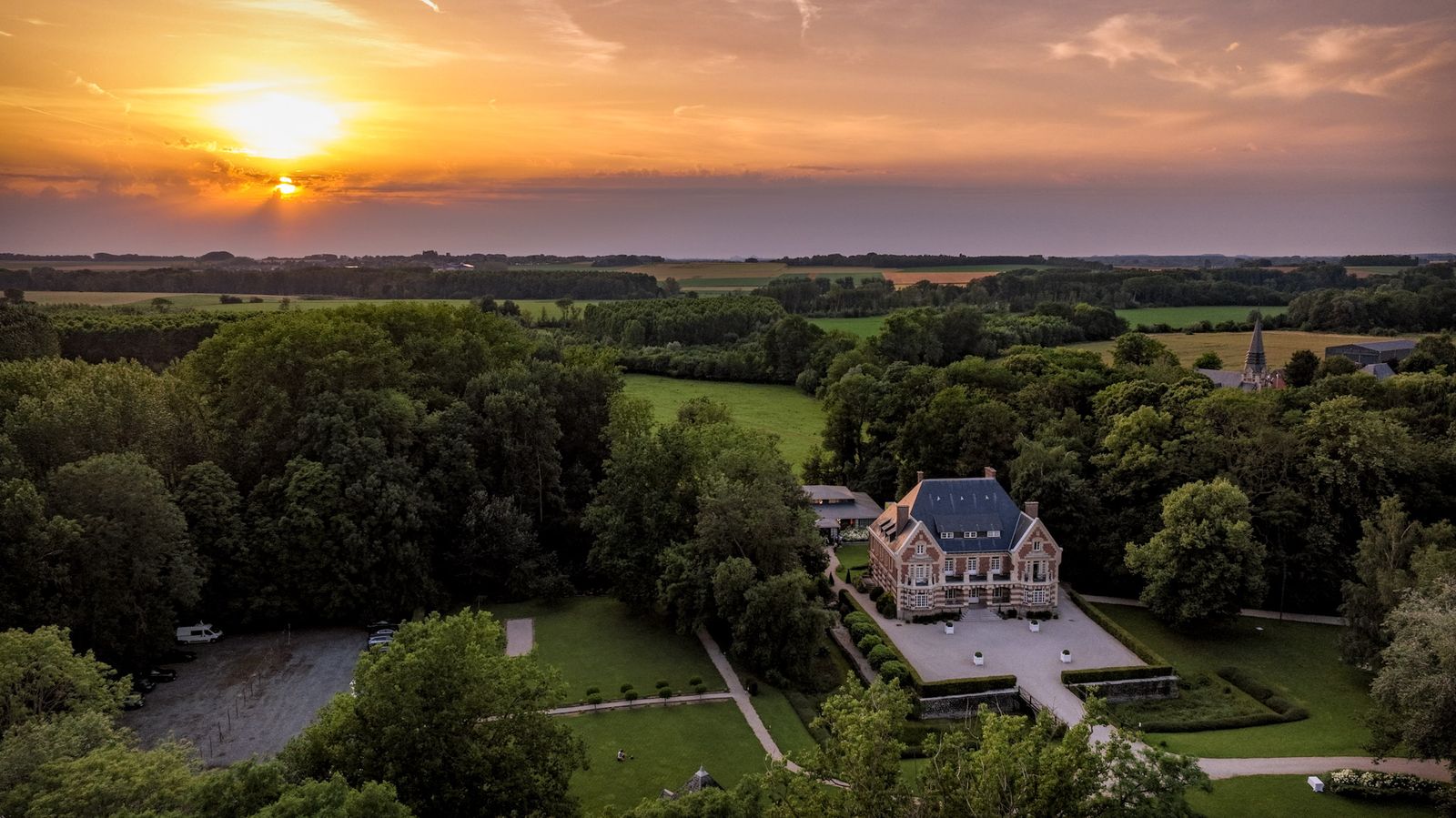 Château et son parc au coucher du soleil, vue aérienne par drone