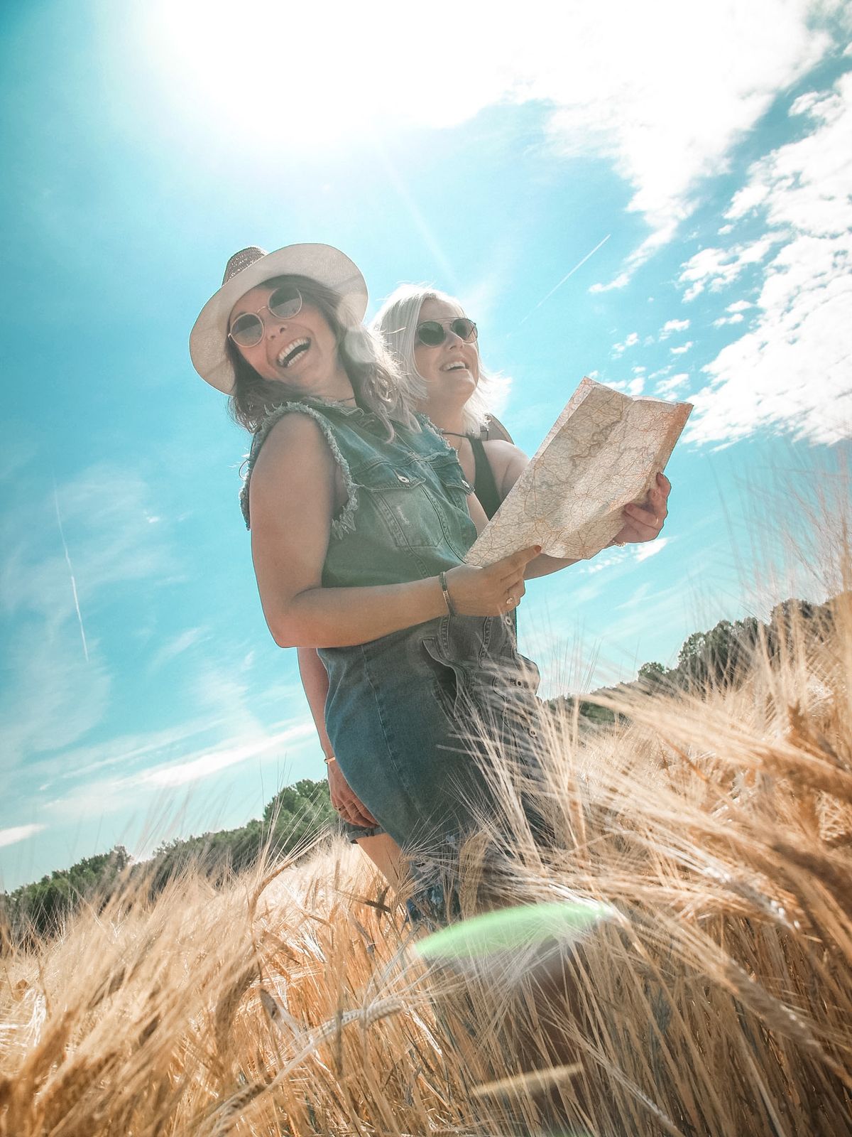 Voyageuse riant dans un champ de blé, carte à la main