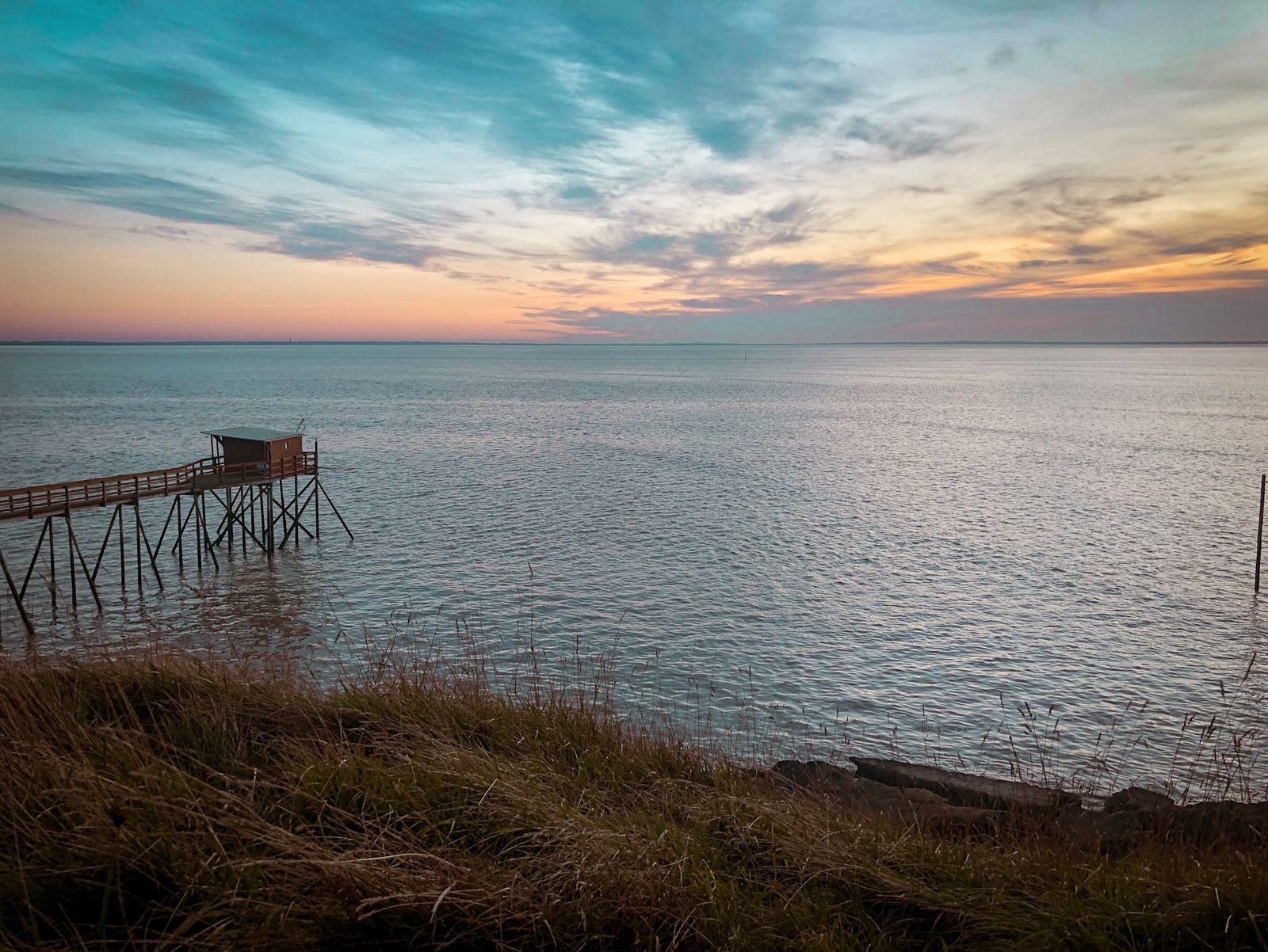 Pêcherie sur pilotis au bord de l’eau, ciel du soir