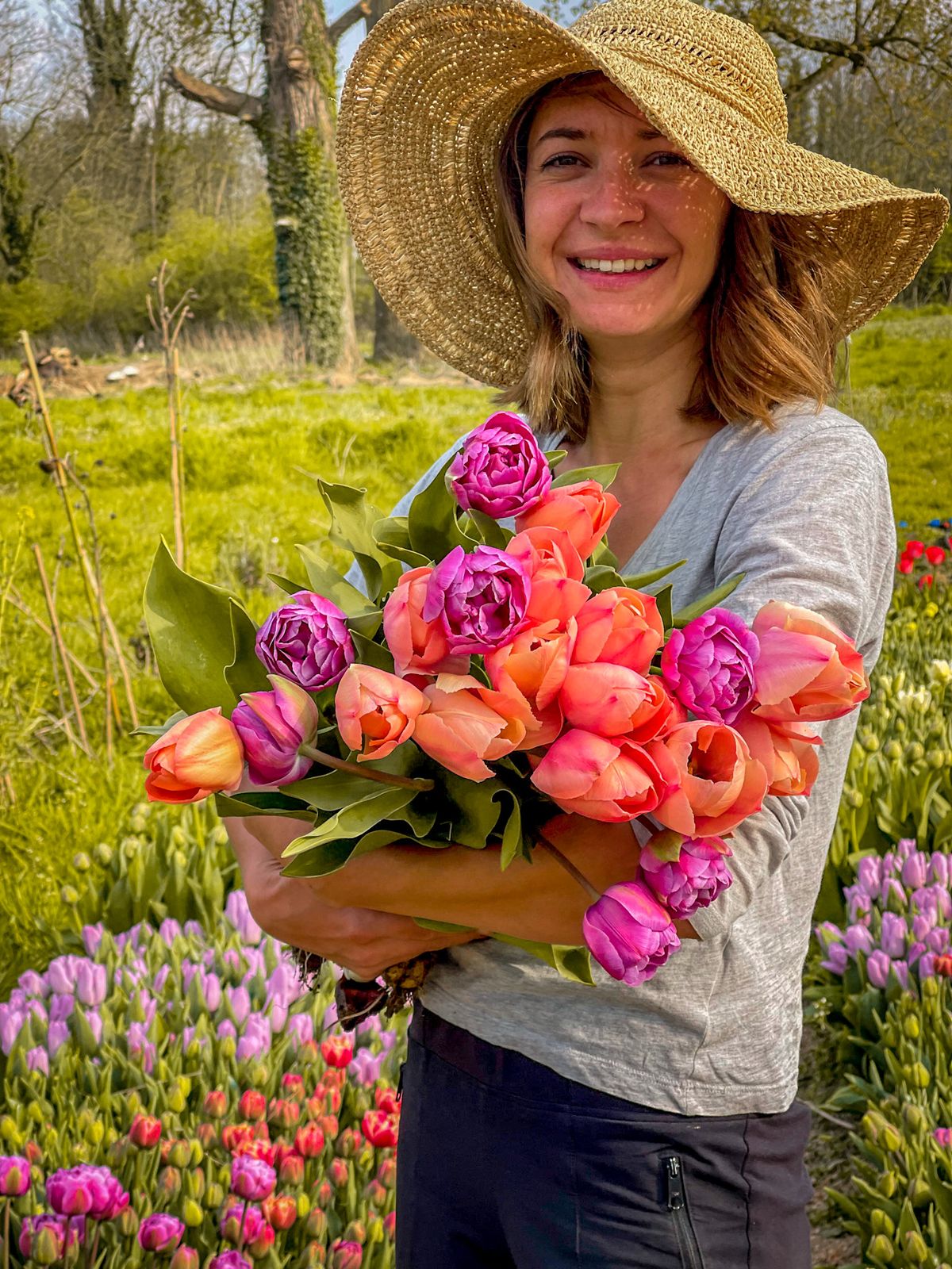 Productrice de fleurs tenant une brassée de tulipes